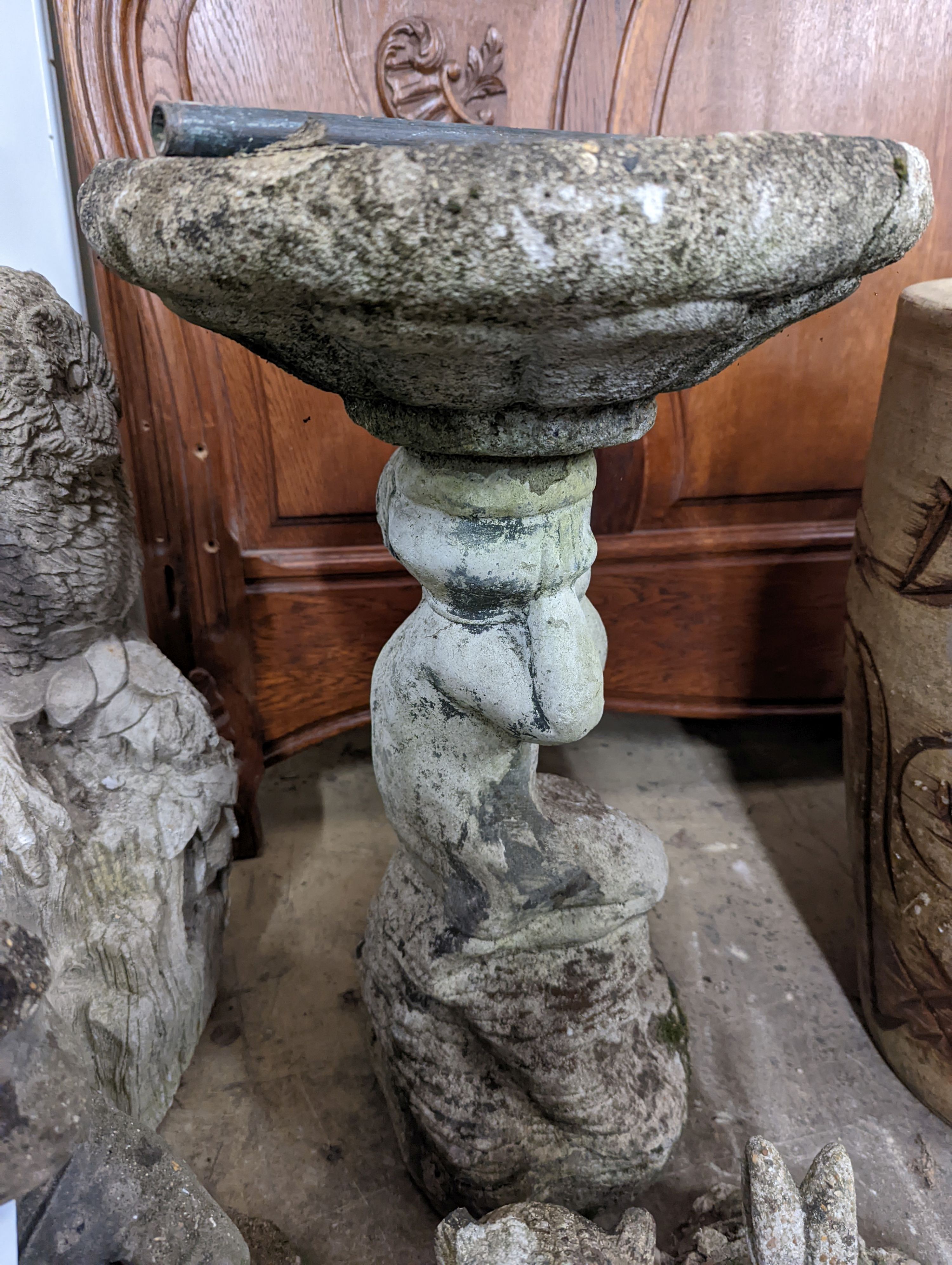 A reconstituted stone garden bird bath, height 59cm, together with four stone garden ornaments
